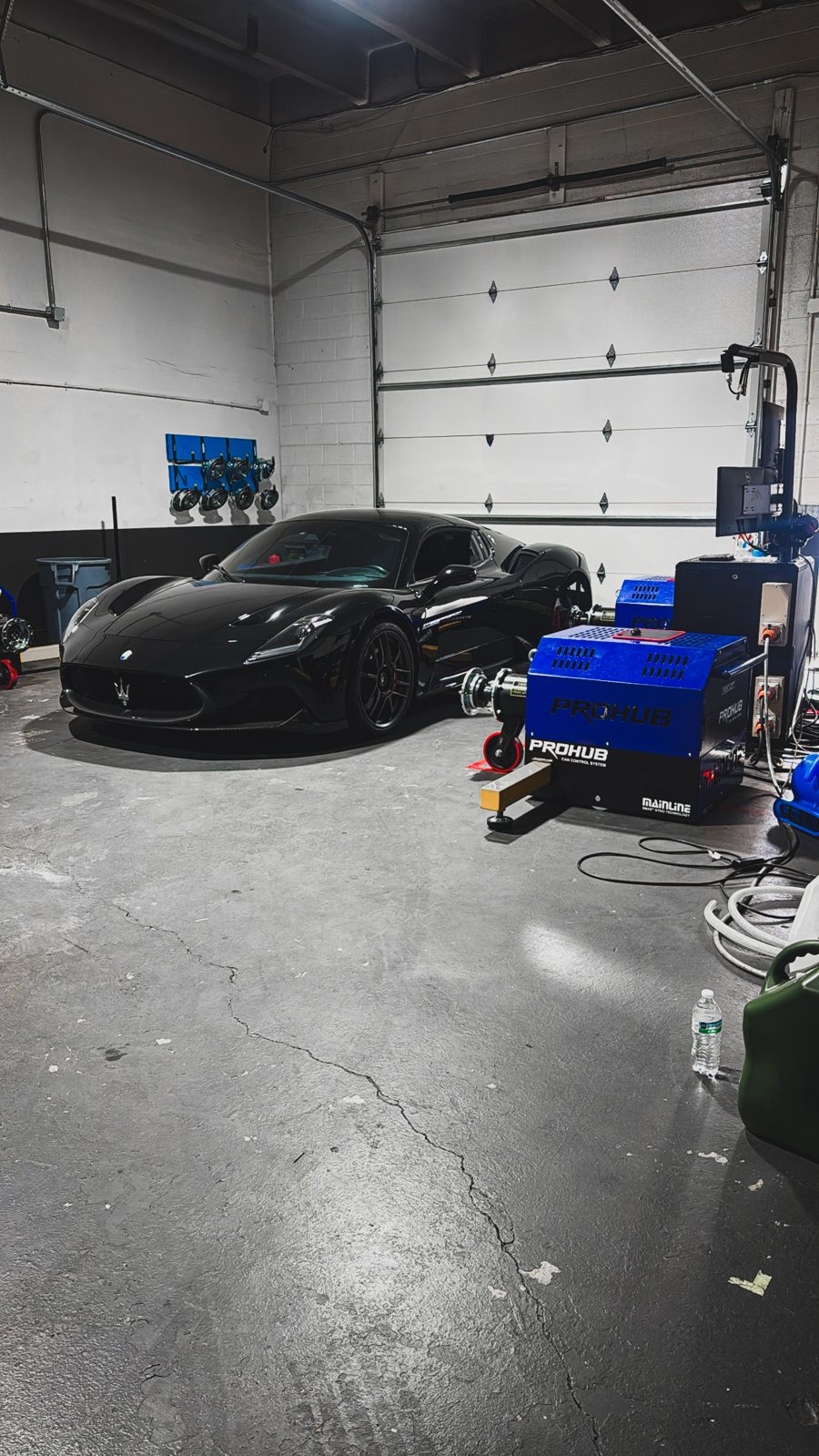 Black Maserati MC20 beside the Mainline ProHub hub dyno in the PME shop